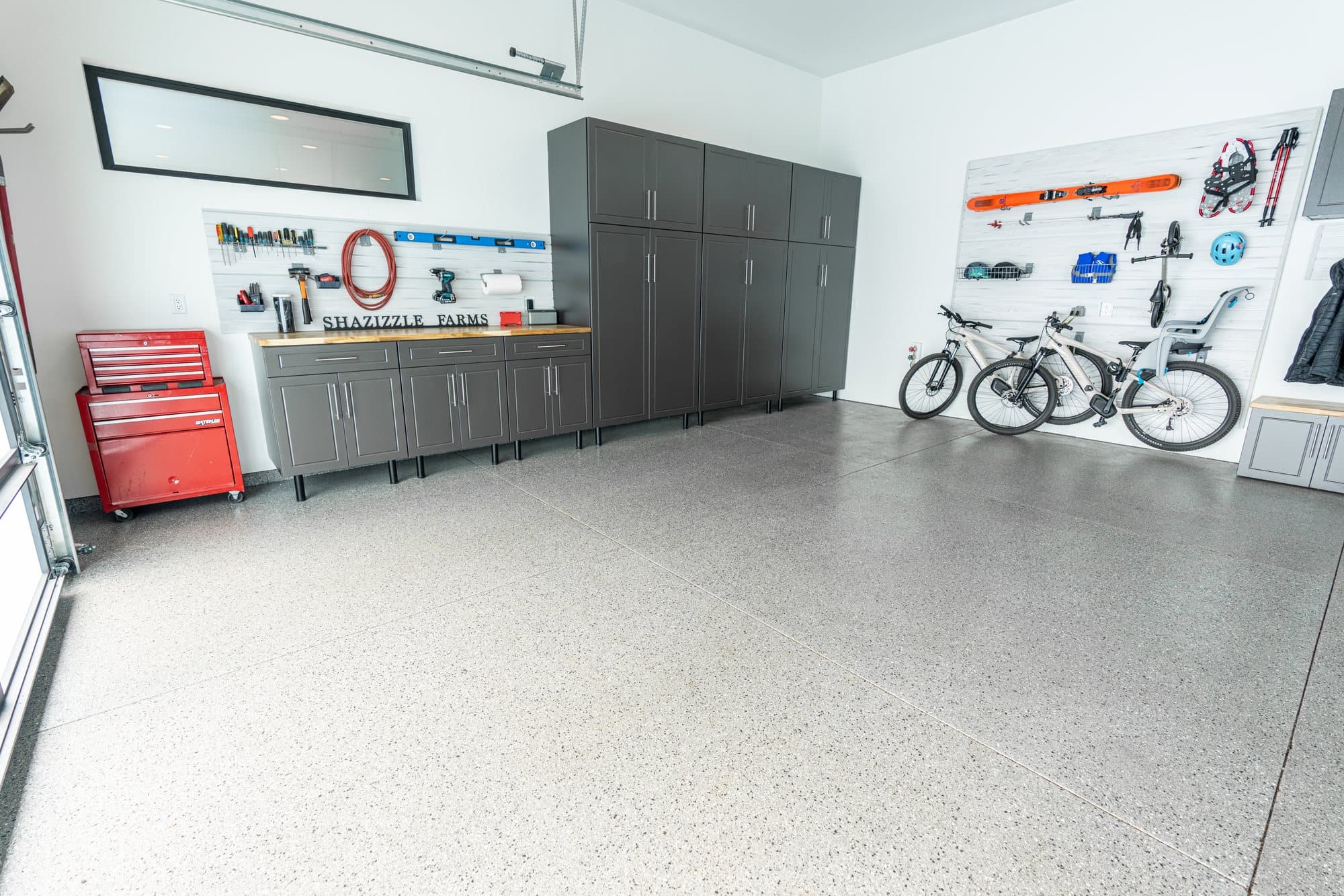 Residential garage with a flake-coated floor, cabinets, and wall storage